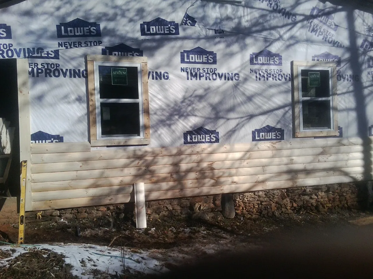 House wrap and new log siding going up on an exterior wall in Churchville